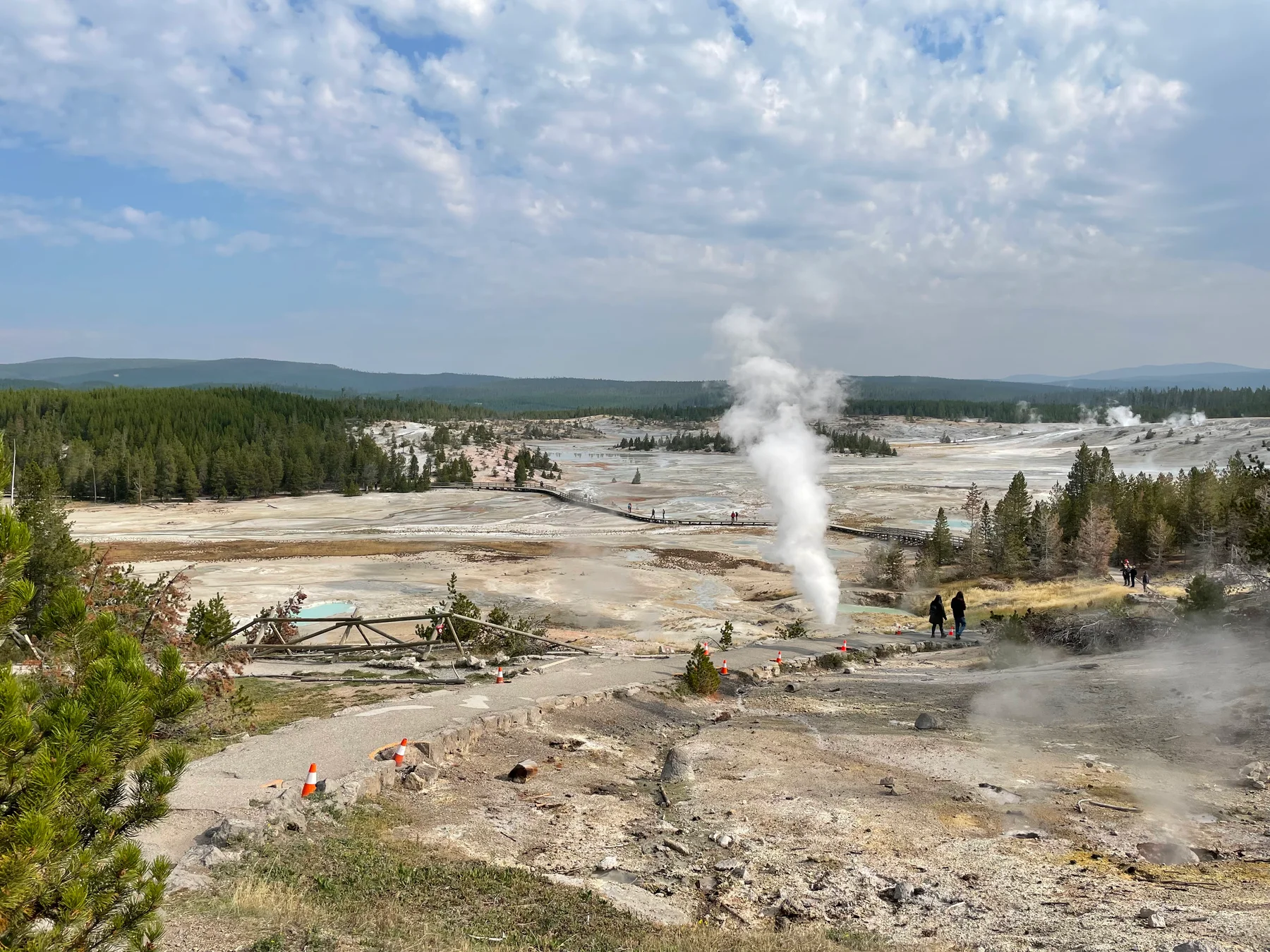 Norris Geyser Basin photographed from Porcelain Basin Overlook in Yellowstone National Park, featuring steam vents and a wooden boardwalk crossing the geothermal area.